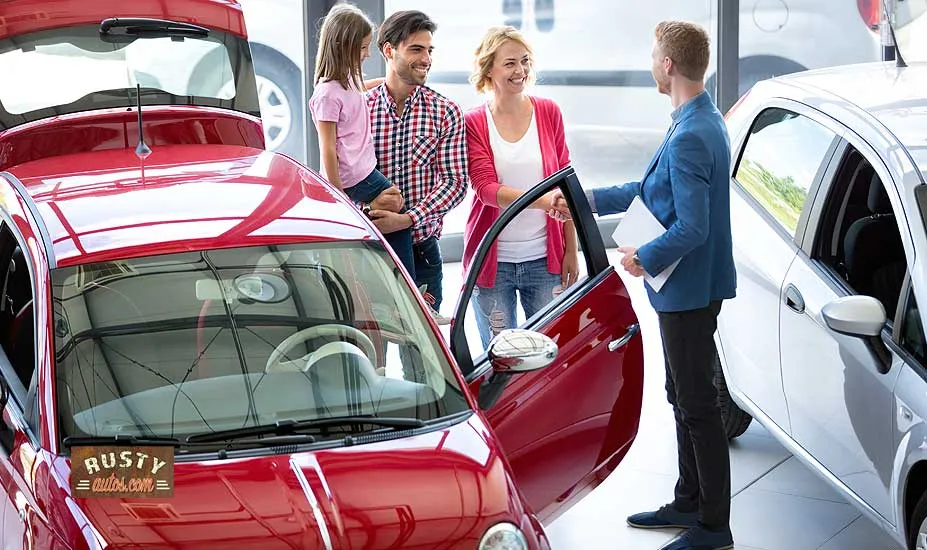 Car salesman with family in showroom